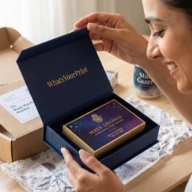 A woman in Mumbai joyfully unboxing premium gold-foiled astrologer business cards from WhatsYourPrint packaging.