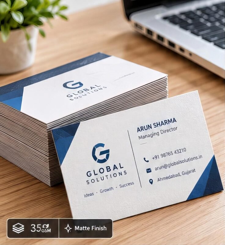A close-up view of premium, matte-finish printed business cards fanned out on a wooden desk.